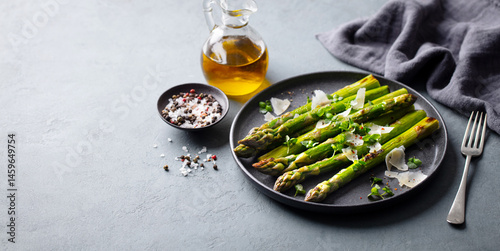 Roasted asparagus with parmesan cheese. Grey background. Copy space.