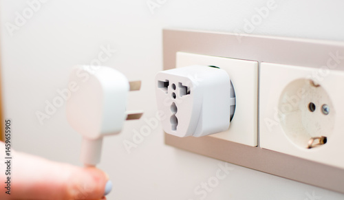 Universal travel adapter in a socket close-up