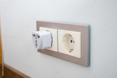 Universal travel adapter in a socket close-up