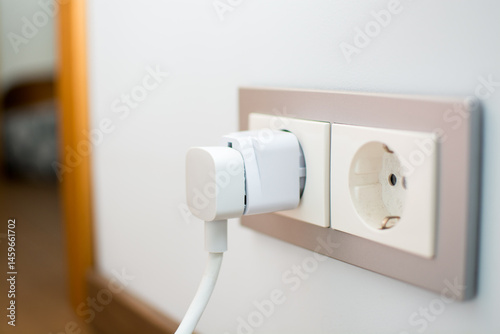 Universal travel adapter in a socket close-up