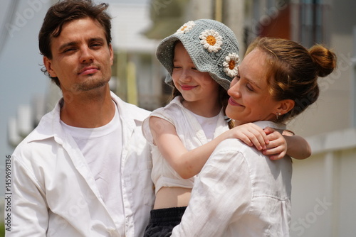 Caucasian family father holding seven year old daughter with mother standing together happily kissing cheek of three new children in housing project planning finance insurance home loan to build futur