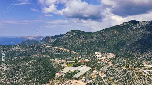 Crystal clear turquoise water gently caressing the shores of a secluded cove, surrounded by lush green hills under a bright sky, creating a peaceful and idyllic mediterranean scenery