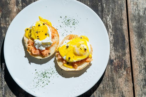 Egg benedict or poached egg with salmon on white plate. Isolated by wooden background or table. Food photography