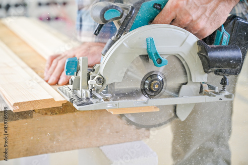 Obraz na płótnie A skilled craftsman operates a circular saw on a wooden plank, showcasing precision and craftsmanship in a well-lit workshop environment, highlighting woodworking techniques w salonie