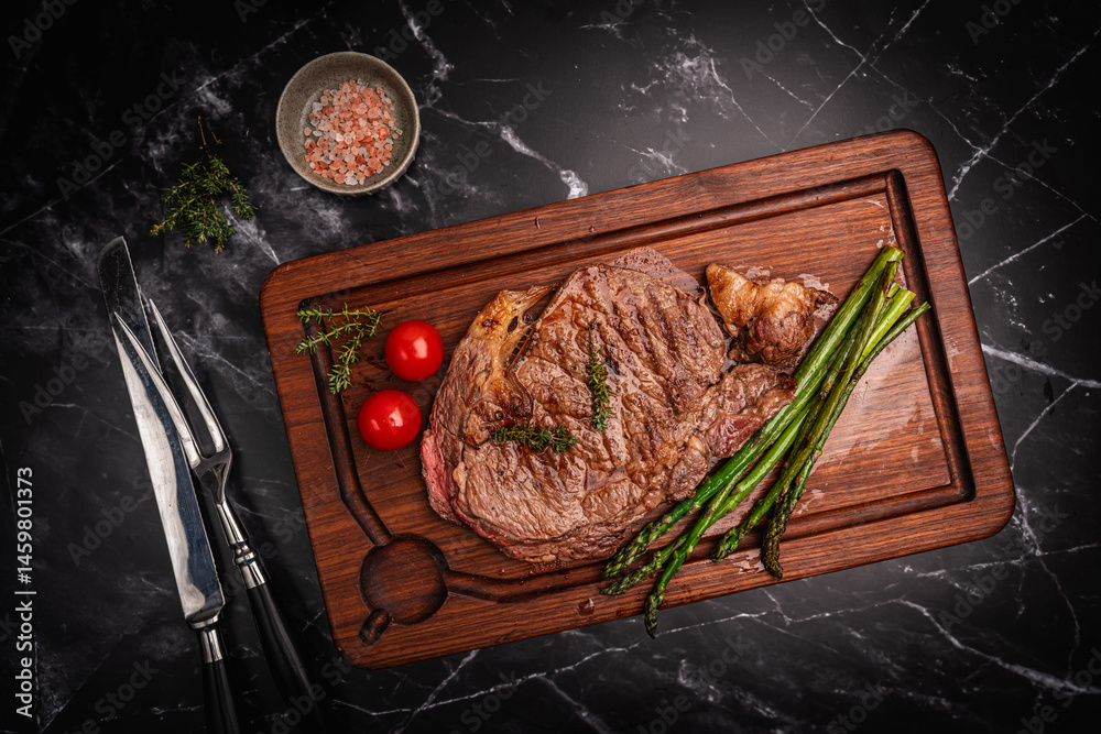 Beef grill steak with green asparagus on a cutting board. Healthy dinner or lunch, top view. High quality photo