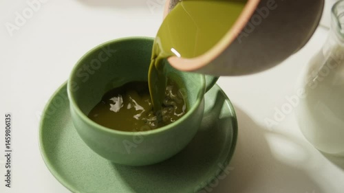 Matcha green tea cooking process, japanese powder green tea in a bowl with bamboo whisk, macro close up in cafe of powder green tea. 