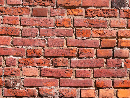Part of a brick wall, red in color, of an old house