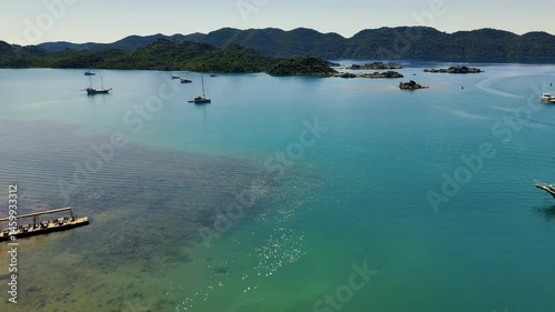 Stunning aerial perspective of the picturesque Kekova Peninsula, highlighting crystal clear turquoise waters, luxurious yachts, and a rugged coastline