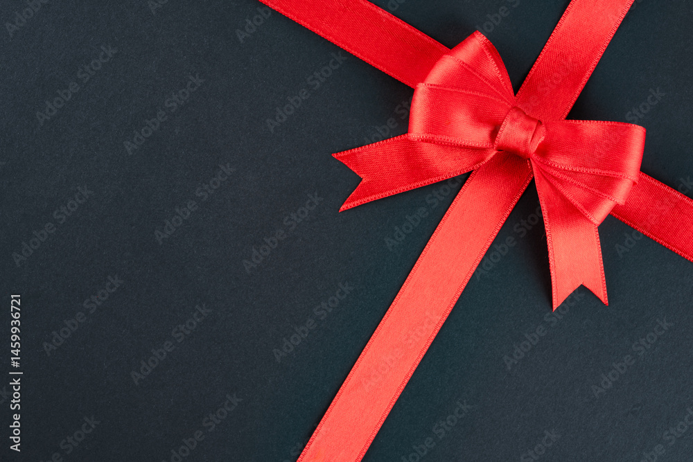 Red ribbon and bow on black background