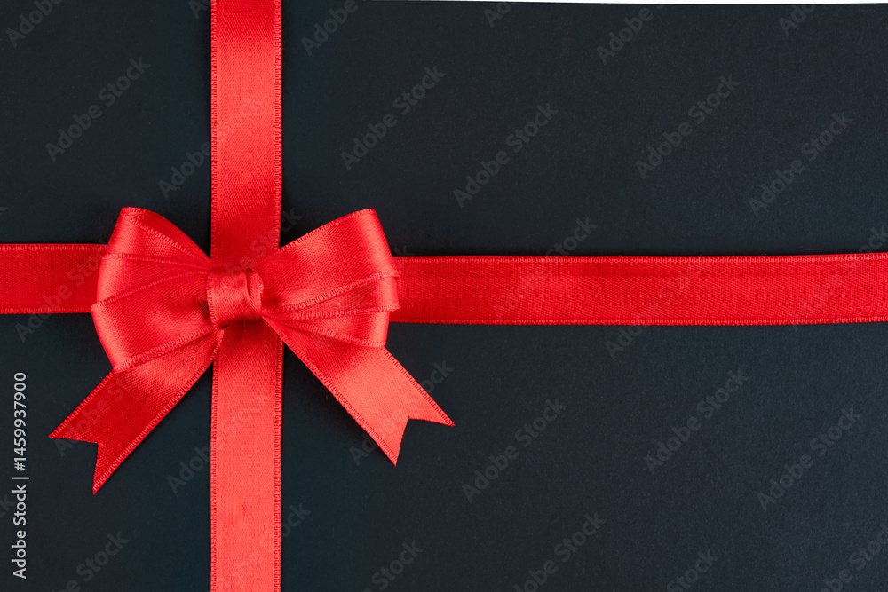Red ribbon and bow on black background