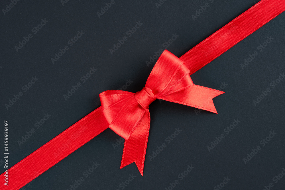 Red ribbon and bow on black background