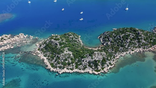 Stunning aerial perspective of the picturesque Kekova Peninsula, highlighting crystal clear turquoise waters, luxurious yachts, and a rugged coastline