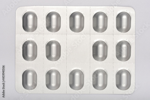 Obraz na płótnie Silver blister pack of oval pills against a neutral background, suggesting medication, healthcare, and pharmaceuticals w salonie