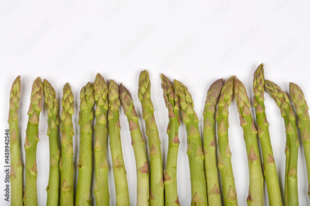 A row of fresh green asparagus spears is positioned along the bottom edge of a plain white background