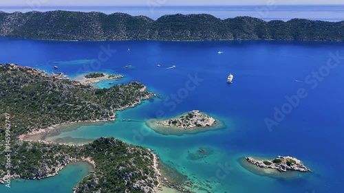 Stunning aerial perspective of the picturesque Kekova Peninsula, highlighting crystal clear turquoise waters, luxurious yachts, and a rugged coastline