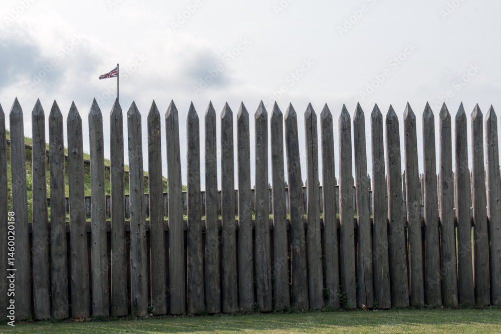 Fototapeta premium A British flag in the distance over a wooden barrier. 