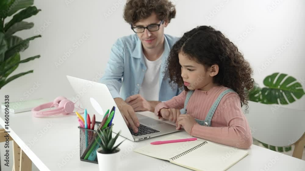 Caucasian father help student doing homework about engineering code while happy school girl. Dad take care cute child while teaching about generative ai at table with laptop and headphone. Pedagogy. Caucasian father help student doing homework about engineering code while happy school girl. Dad take care cute child while teaching about generative ai at table with laptop and headphone. Pedagogy.