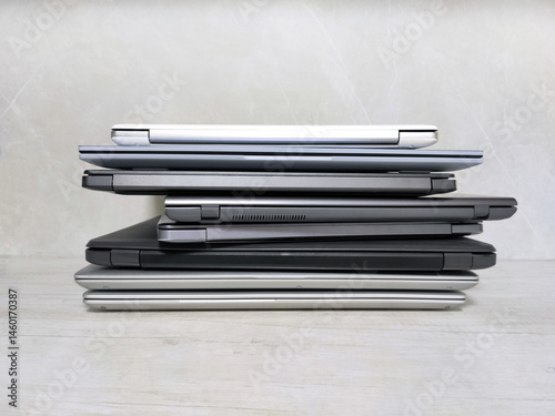 stack of laptops on a gray background, on the table, laptop computer, tablet, business, work, remote work, freelance.