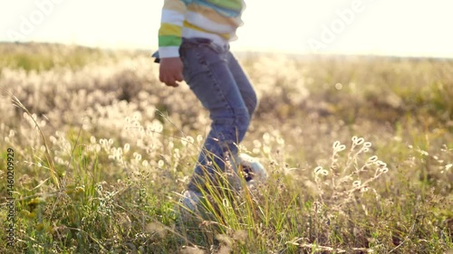 Child girl boy joyfully play game football park during summer. kick ball feet grassy field, enjoying outdoor environment. delightful scene happy family parents watch daughter son running having fun.