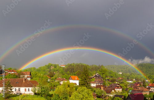 Obraz na płótnie A double rainbow over a village w salonie