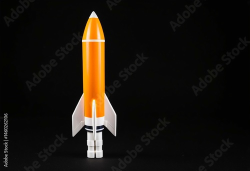 An orange and white toy rocket on a black background.
