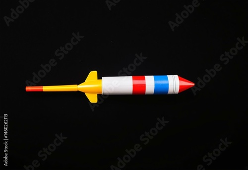 An orange and white toy rocket on a black background.
