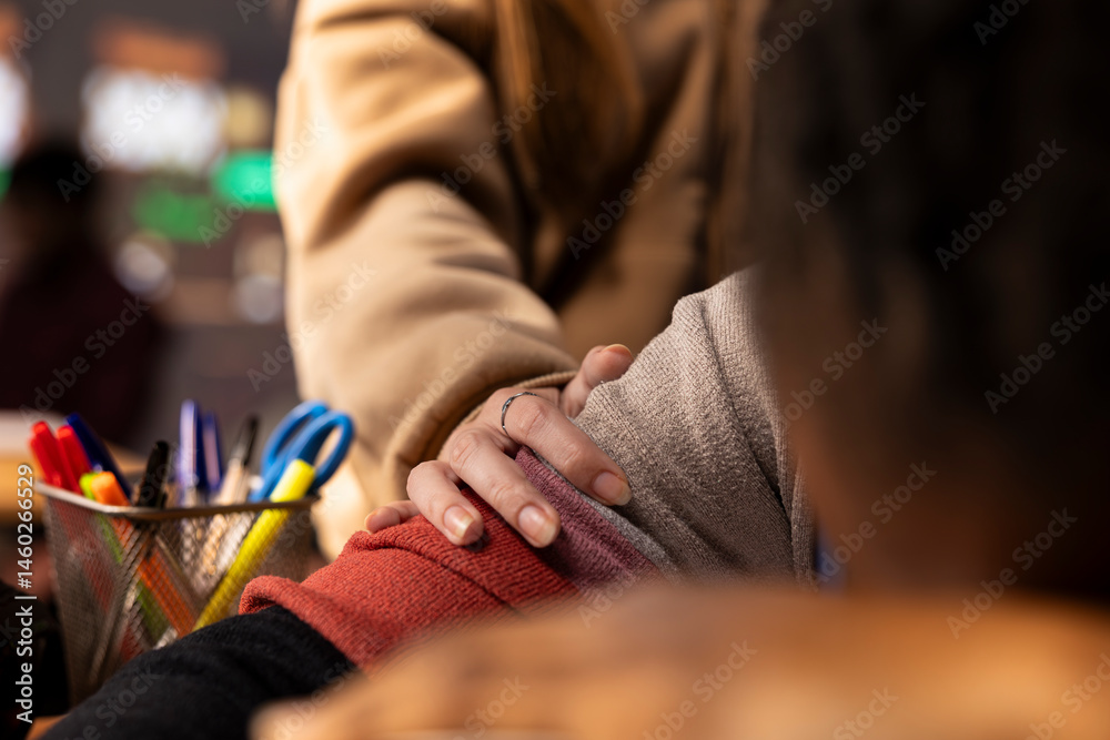 Young girl wakes up her colleague in the campus library after falling asleep on her books and study materials, sleep deprived student. Pupil feeling tired with burnout, studying all night. Close up.