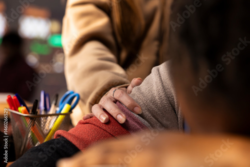 Obraz na płótnie Young girl wakes up her colleague in the campus library after falling asleep on her books and study materials, sleep deprived student. Pupil feeling tired with burnout, studying all night. Close up. w salonie