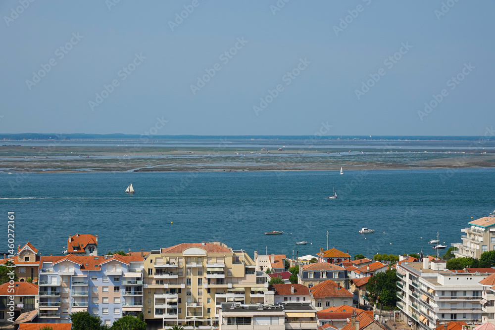 view of the sea, yachts and oyster farms behind the roofs of the city