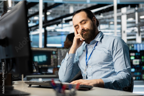 Exhausted server hub worker falling asleep at desk after repeated debugging attempts. Tired technician in data center sleeping in office after long hardware troubleshooting session