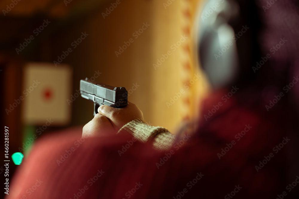 Woman in firing range doing recreational shooting activity with firearm, hitting bullseyes. Close up of person in shooting gallery training with handgun, sharpening skills, developing muscle memory