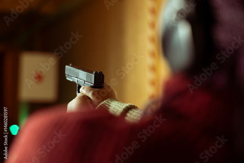 Obraz na płótnie Woman in firing range doing recreational shooting activity with firearm, hitting bullseyes. Close up of person in shooting gallery training with handgun, sharpening skills, developing muscle memory w salonie