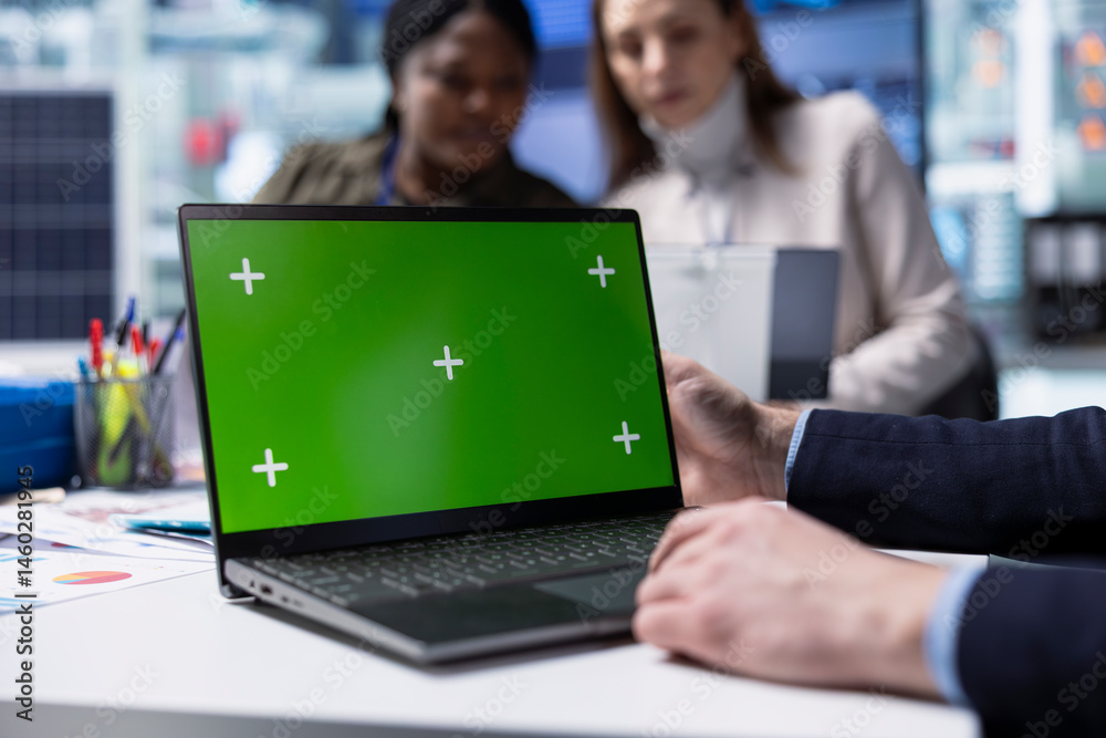 Factory employee works on green screen laptop next to executives discussing solar panel automation strategies. Worker typing on mockup notebook next to team enhancing manufacturing processes, Close up