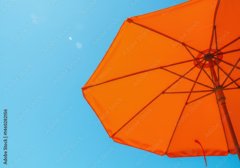 View looking up at a vibrant orange beach umbrella against a clear bright blue sky background View looking up at a vibrant orange beach umbrella against a clear bright blue sky background