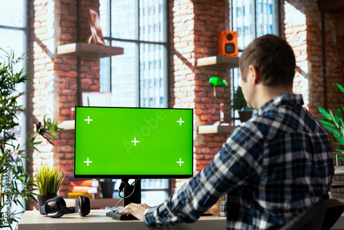Obraz na płótnie Freelancer in home office completing spreadsheets on mockup computer, entering data, calculating totals. Remotely working accountant analyzing figures on green screen PC, using spreadsheet software w salonie