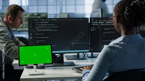 Obraz na płótnie Isolated screen tablet in front of IT support workers coding on computers, upgrading equipment. Engineers at PC desk overseeing server clusters using chroma key device, camera A w salonie