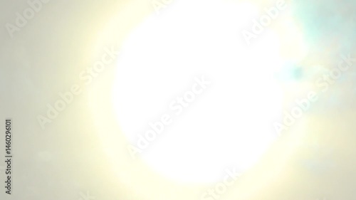 Beautiful and vibrant image depicting the powerful rays of the sun glowing through the clouds moving beneath. Represents shining brightness, energy, and the dynamism of nature's celestial beauty.