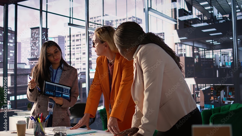 Multiethnic women executives uniting forces in a collaborative meeting, focused on data management and business development. Experts with leadership skills fighting for empowerment. Camera B.