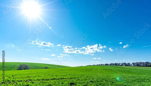 Vibrant Green Field Under Bright Blue Sky with Shining Sun and Fluffy White Clouds