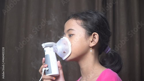 Little girl makes inhalation with a nebulizer. Children's asthma inhaler cough steam inhalation
