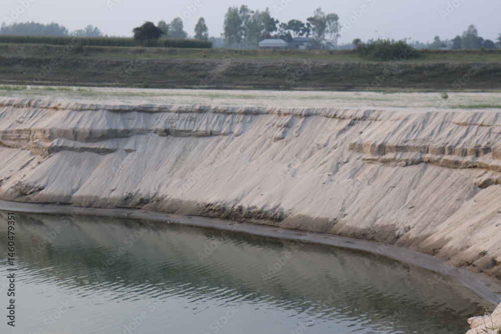 Scenic Landscape Sand Quarry Cliff Face with Water Reflection under Sky