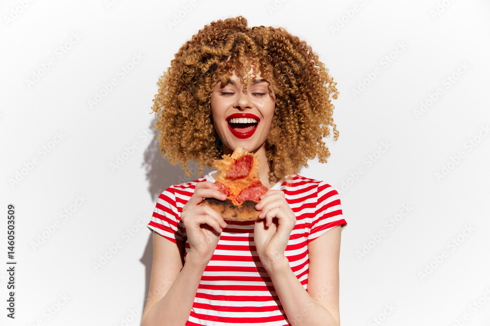 Smiling young woman with curly hair in striped shirt holding a slice of pizza, showcasing joy and love for food against a bright white background