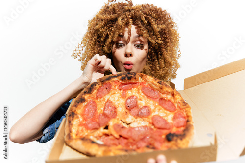 Excited woman with curly hair enjoying a large pizza, showcasing a fresh pepperoni pizza from the box, vivid colors and expressive emotions provide a fun and appetizing image
