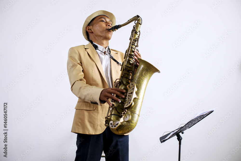Fototapeta premium Young Musician Man In Formal Suit Playing Saxophone While Standing