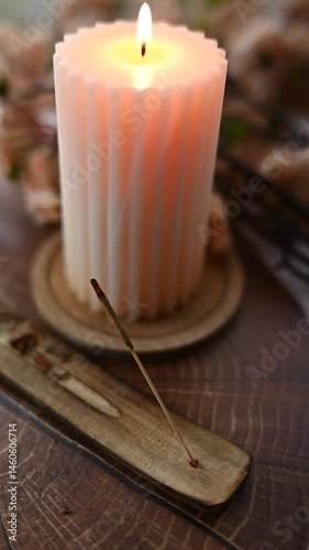 Cozy spring candlelit setup with aromatic incense stick smoke and floral background, creating a serene, calming, and peaceful atmosphere