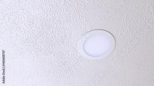 Close-up of a Simple White Ceiling Light on a Textured Surface