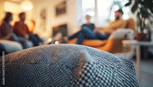 Cozy Gathering: A Blurred Background of Friends Enjoying Each Other's Company, Emphasized by a Close-Up of a Textured Throw Pillow