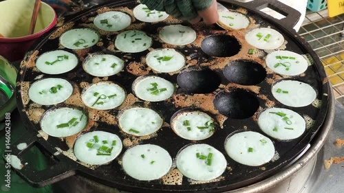 Khanom Khrok is a traditional Thai coconut-rice pancake, famous for its sweet, creamy, and slightly crispy texture. It is cooked in a special cast-iron pan with small round molds
