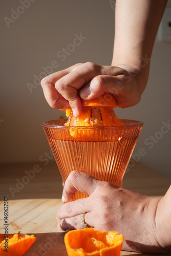 Freshly squeezed orange juice preparation in a sunny kitchen