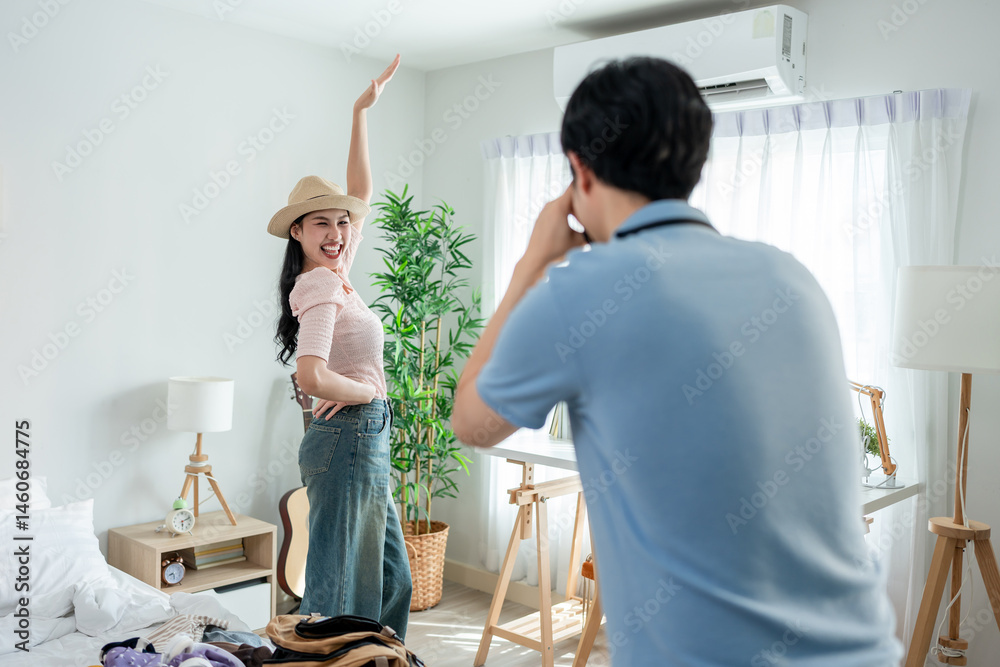 Fototapeta premium Asian young man using camera taking photo of girlfriend preparing for next trip.
